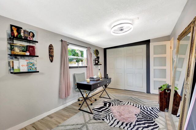 115 W 31st Ct, Riviera Beach, FL 33404 - office space with light wood-style flooring, a textured ceiling, and baseboards