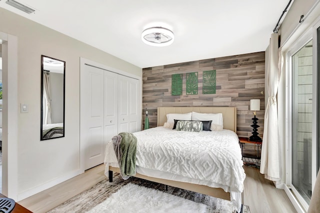 115 W 31st Ct, Riviera Beach, FL 33404 - bedroom featuring an accent wall, a closet, light wood-type flooring, and visible vents