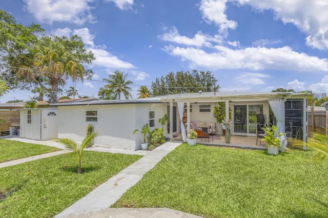 115 W 31st Ct, Riviera Beach, FL 33404 - rear view of property featuring a lawn, stucco siding, and fence
