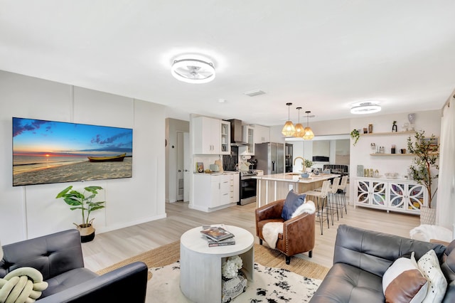 115 W 31st Ct, Riviera Beach, FL 33404 - living area with baseboards, light wood-style floors, and visible vents