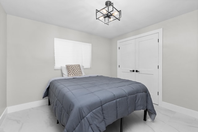 2500 NE 23rd St, Pompano Beach, FL 33062 - bedroom featuring baseboards, marble finish floor, a notable chandelier, and a closet