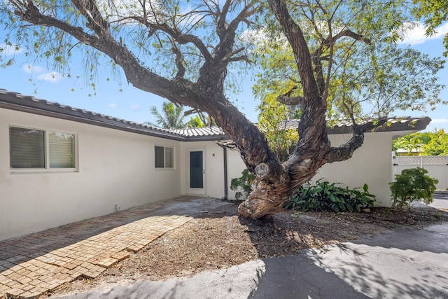 2500 NE 23rd St, Pompano Beach, FL 33062 - exterior space with stucco siding, a tiled roof, fence, and a patio