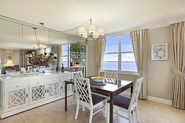 2121 N Ocean Blvd Unit 1707E, Boca Raton, FL 33431 - dining space with a chandelier, a water view, tile patterned floors, ornamental molding, and baseboards