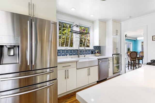 335 Monroe Dr, West Palm Beach, FL 33405 - kitchen featuring appliances with stainless steel finishes, light countertops, a sink, white cabinetry, and recessed lighting