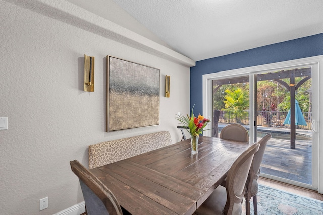 18143 42nd Rd, The Acreage, FL 33470 - dining area featuring a textured wall, vaulted ceiling, wood finished floors, and baseboards
