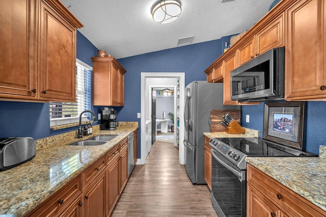18143 42nd Rd, The Acreage, FL 33470 - kitchen featuring appliances with stainless steel finishes, a sink, lofted ceiling, a textured ceiling, and wood finished floors