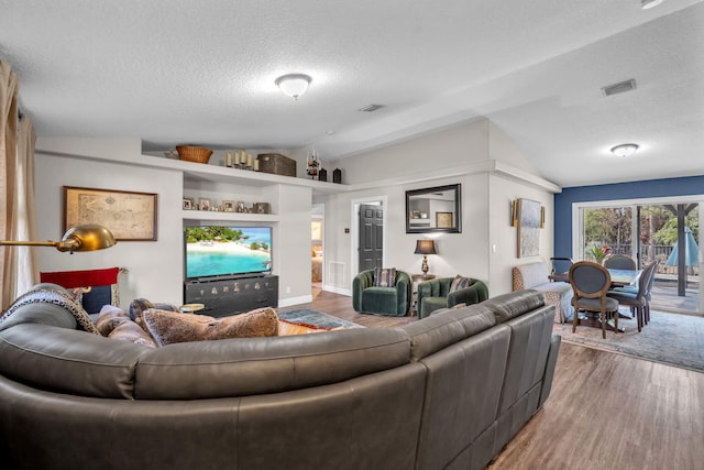 18143 42nd Rd, The Acreage, FL 33470 - living room featuring vaulted ceiling, a textured ceiling, and wood finished floors
