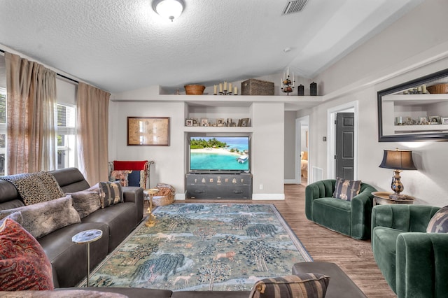 18143 42nd Rd, The Acreage, FL 33470 - living area featuring lofted ceiling, wood finished floors, a textured ceiling, and baseboards