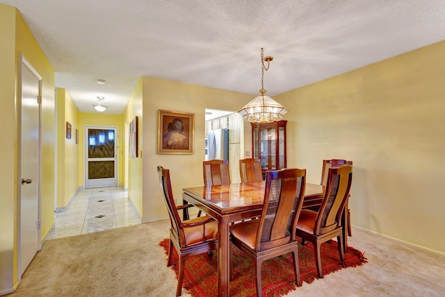 dining area with a chandelier and light carpet