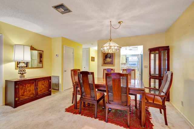dining area with light colored carpet and a chandelier