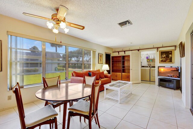 dining room featuring separate washer and dryer, healthy amount of natural light, ceiling fan, a textured ceiling, and light tile patterned flooring