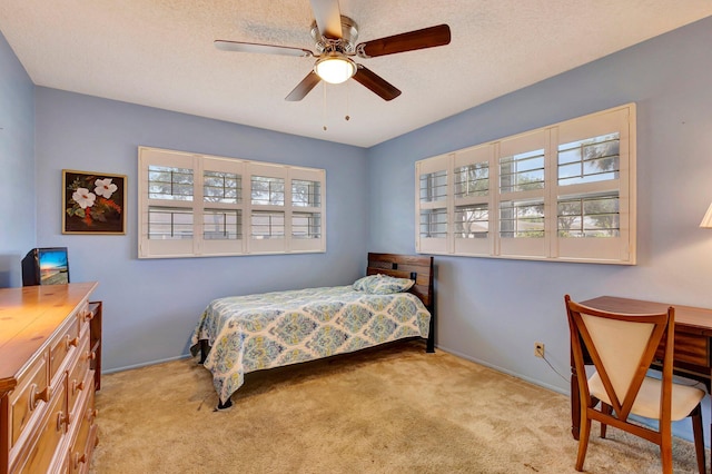 bedroom with multiple windows, carpet flooring, a textured ceiling, a ceiling fan, and baseboards