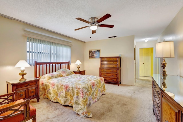 bedroom featuring light carpet, a textured ceiling, and a ceiling fan
