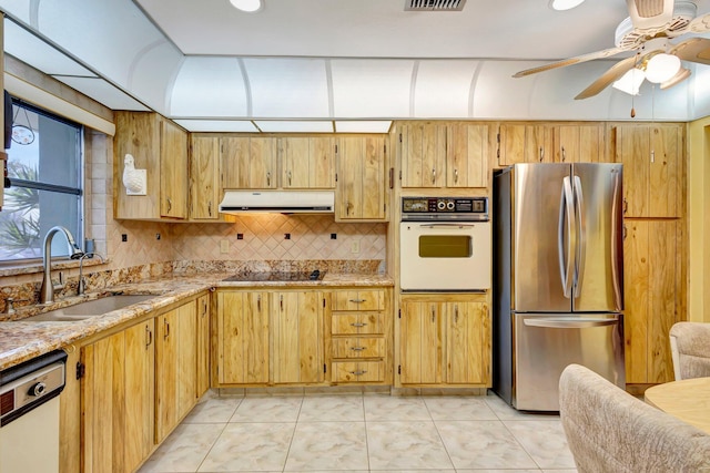 kitchen with white appliances, a sink, ventilation hood, a ceiling fan, and light stone counters