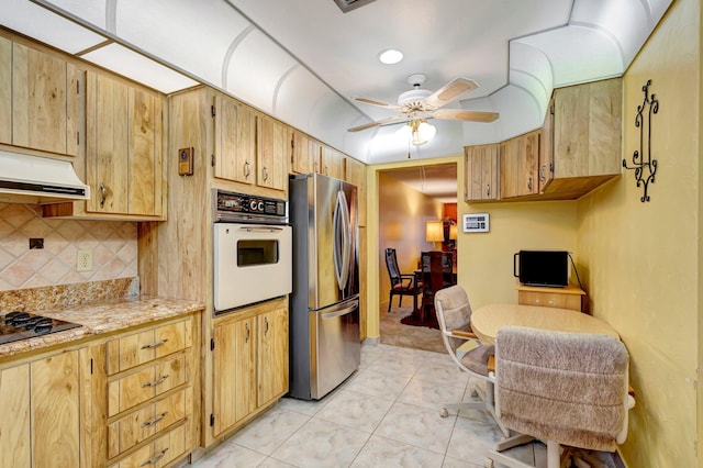 kitchen with freestanding refrigerator, oven, black electric cooktop, ventilation hood, and ceiling fan