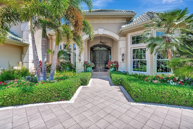 7701 SE Manhasset Pl, Hobe Sound, FL 33455 - view of exterior entry featuring stucco siding, a tile roof, and french doors