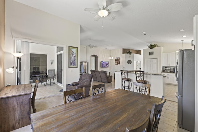 1235 SW Briarwood Dr, Port Saint Lucie, FL 34986 - dining area featuring a ceiling fan, light tile patterned flooring, arched walkways, and vaulted ceiling