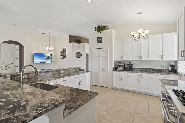 1235 SW Briarwood Dr, Port Saint Lucie, FL 34986 - kitchen featuring a chandelier, a sink, vaulted ceiling, arched walkways, and decorative backsplash