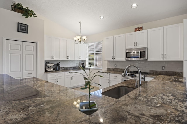 1235 SW Briarwood Dr, Port Saint Lucie, FL 34986 - kitchen with stainless steel appliances, a chandelier, white cabinetry, a sink, and a textured ceiling