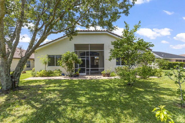 1235 SW Briarwood Dr, Port Saint Lucie, FL 34986 - rear view of property featuring stucco siding, a yard, and a tiled roof