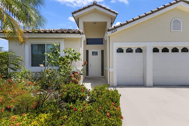 1235 SW Briarwood Dr, Port Saint Lucie, FL 34986 - view of front of house featuring a tiled roof, concrete driveway, stucco siding, and a garage