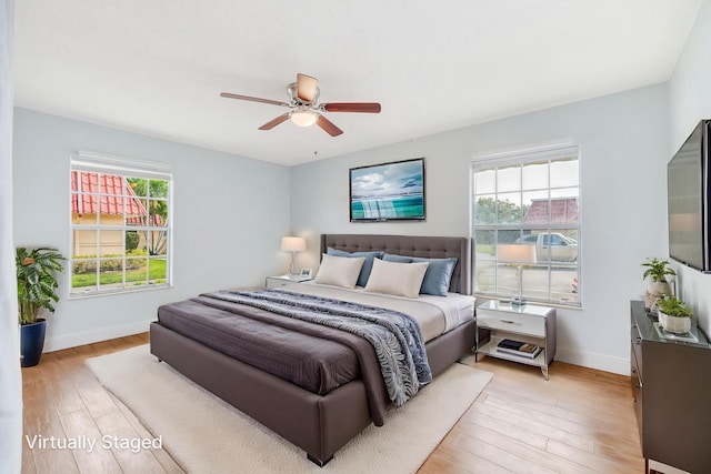 bedroom with baseboards, light wood finished floors, and ceiling fan