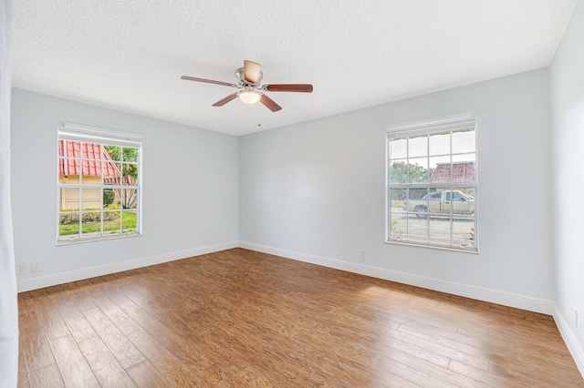 unfurnished room with hardwood / wood-style flooring, a textured ceiling, baseboards, and a ceiling fan
