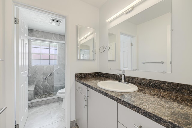 bathroom featuring toilet, visible vents, a shower stall, marble finish floor, and vanity
