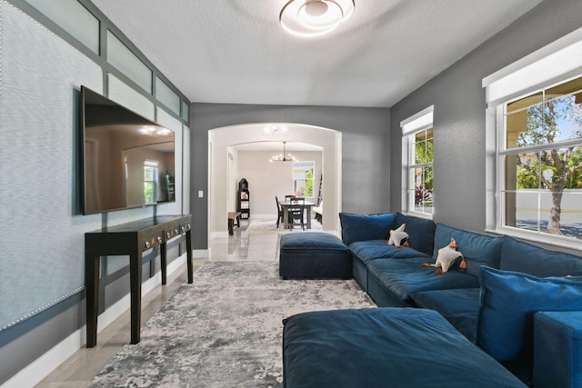 111 Tullamore Ave, Jupiter, FL 33458 - living area featuring arched walkways, a chandelier, baseboards, and a textured ceiling