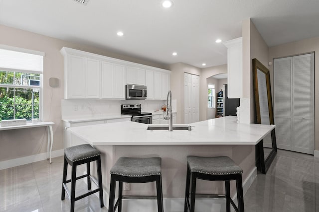 111 Tullamore Ave, Jupiter, FL 33458 - kitchen featuring stainless steel appliances, a sink, arched walkways, baseboards, and healthy amount of natural light