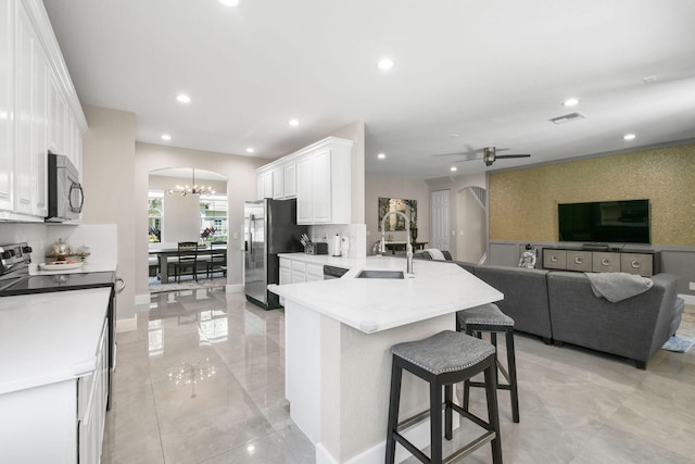 111 Tullamore Ave, Jupiter, FL 33458 - kitchen with stainless steel appliances, a sink, arched walkways, a chandelier, and a peninsula