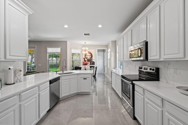 111 Tullamore Ave, Jupiter, FL 33458 - kitchen featuring appliances with stainless steel finishes, a sink, tasteful backsplash, a peninsula, and recessed lighting