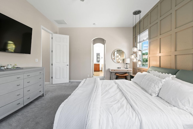 111 Tullamore Ave, Jupiter, FL 33458 - bedroom with arched walkways, light colored carpet, ensuite bathroom, and baseboards