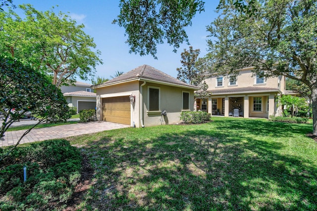 111 Tullamore Ave, Jupiter, FL 33458 - view of front of home featuring stucco siding, a front yard, driveway, and a garage