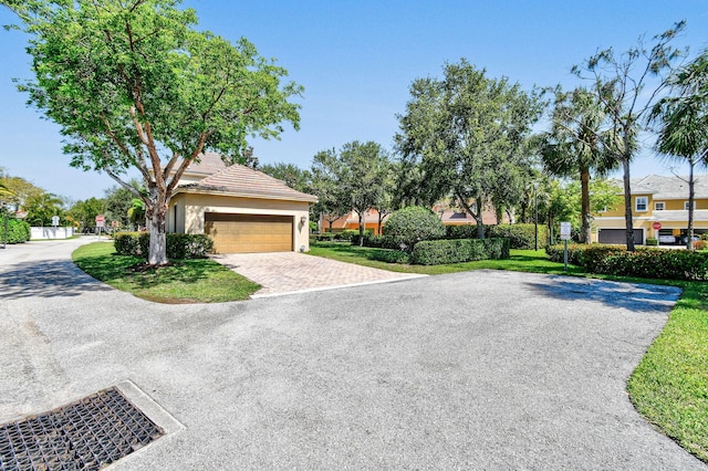 111 Tullamore Ave, Jupiter, FL 33458 - view of front of house with driveway, stucco siding, a garage, and a tile roof