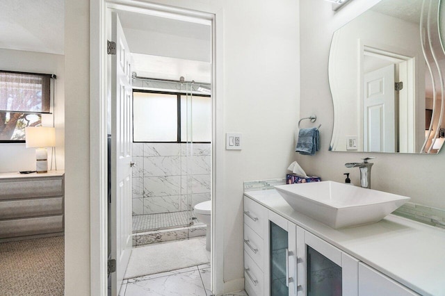full bath with marble look tile flooring, a stall shower, toilet, and vanity