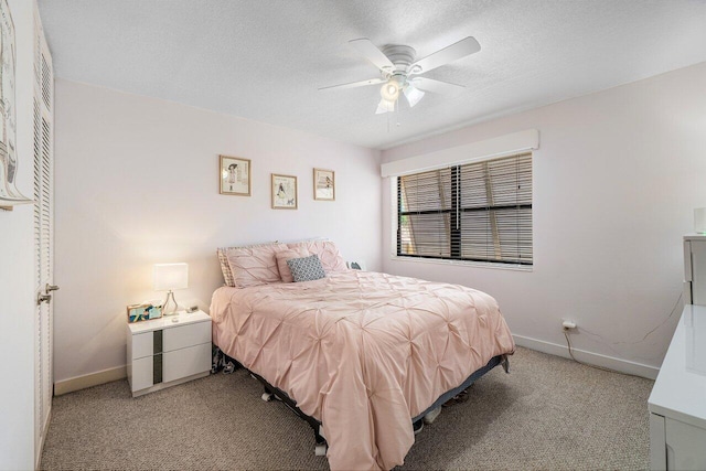 bedroom with light colored carpet, baseboards, a textured ceiling, and a ceiling fan