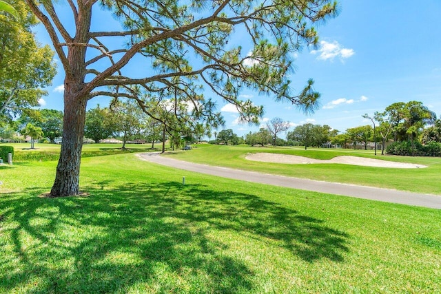 view of home's community with a lawn and view of golf course