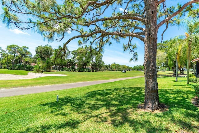 surrounding community with a yard and view of golf course