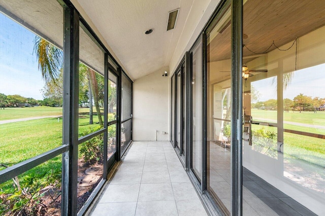 unfurnished sunroom with healthy amount of natural light and a ceiling fan