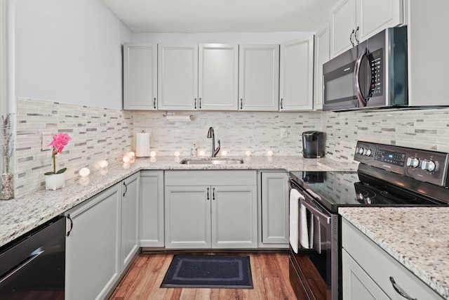 764 Westwind Dr, North Palm Beach, FL 33408 - kitchen featuring appliances with stainless steel finishes, a sink, light wood-style flooring, and light stone countertops