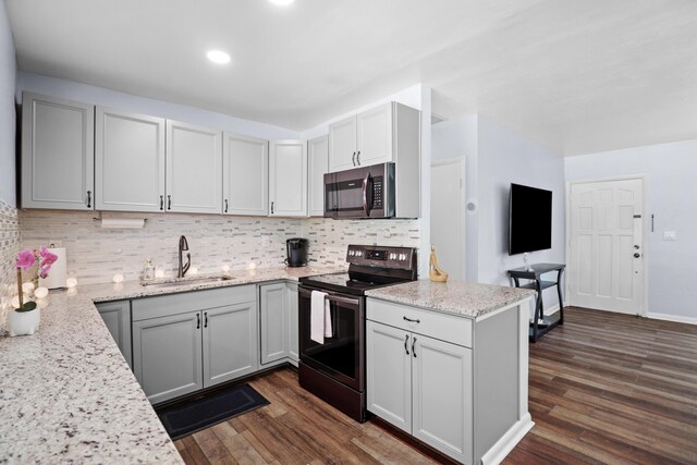 764 Westwind Dr, North Palm Beach, FL 33408 - kitchen with appliances with stainless steel finishes, a sink, dark wood-style flooring, decorative backsplash, and light stone counters