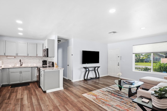 764 Westwind Dr, North Palm Beach, FL 33408 - kitchen with a sink, appliances with stainless steel finishes, light stone countertops, backsplash, and open floor plan