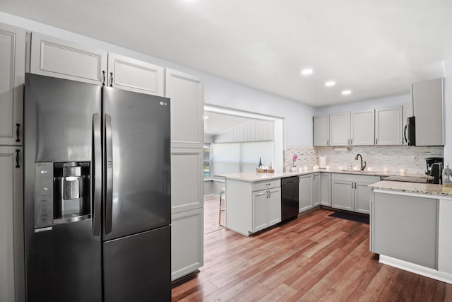 764 Westwind Dr, North Palm Beach, FL 33408 - kitchen featuring appliances with stainless steel finishes, a sink, light wood-style flooring, backsplash, and a peninsula