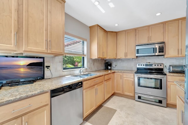 8030 Eastlake Dr Unit 10B, Boca Raton, FL 33433 - kitchen featuring appliances with stainless steel finishes, light brown cabinetry, a sink, light stone counters, and decorative backsplash