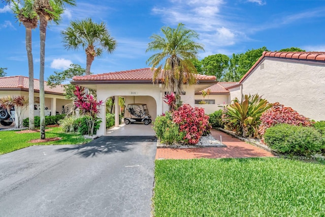 8030 Eastlake Dr Unit 10B, Boca Raton, FL 33433 - mediterranean / spanish-style house with driveway, a tile roof, a carport, stucco siding, and a front lawn