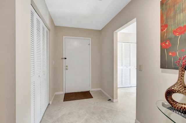 8030 Eastlake Dr Unit 10B, Boca Raton, FL 33433 - foyer featuring baseboards and light tile patterned floors