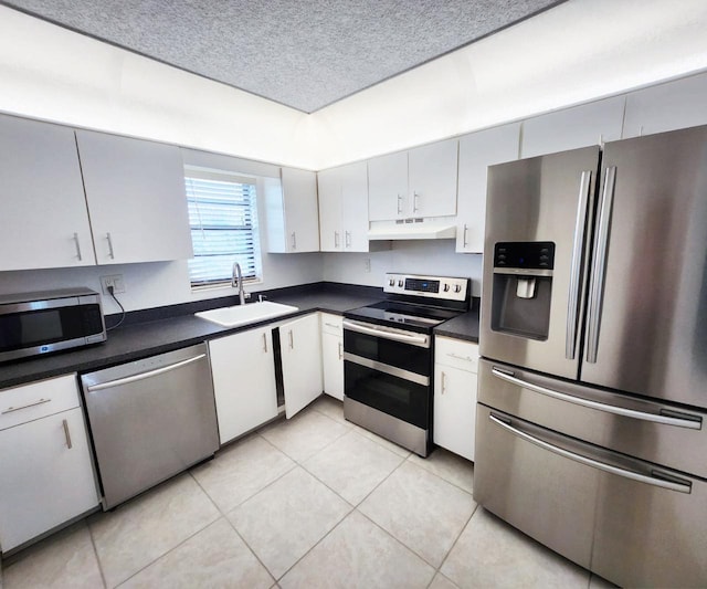 9235 SW 8th St Unit 402, Boca Raton, FL 33428 - kitchen with appliances with stainless steel finishes, a sink, under cabinet range hood, dark countertops, and light tile patterned floors