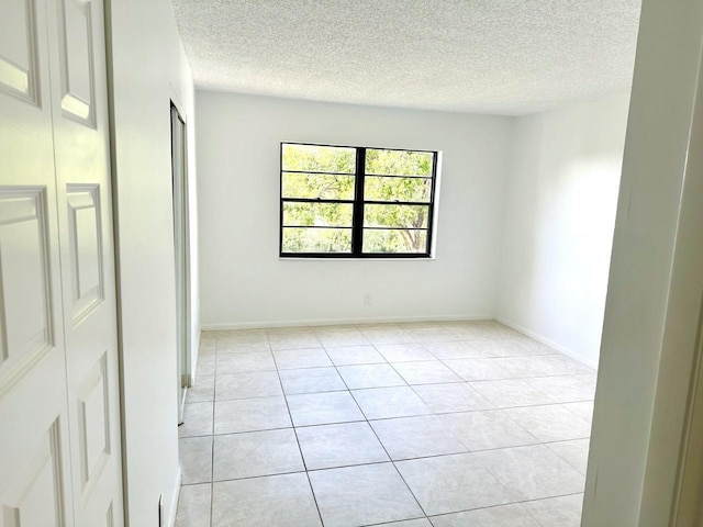 9235 SW 8th St Unit 402, Boca Raton, FL 33428 - unfurnished room featuring a textured ceiling, light tile patterned floors, and baseboards