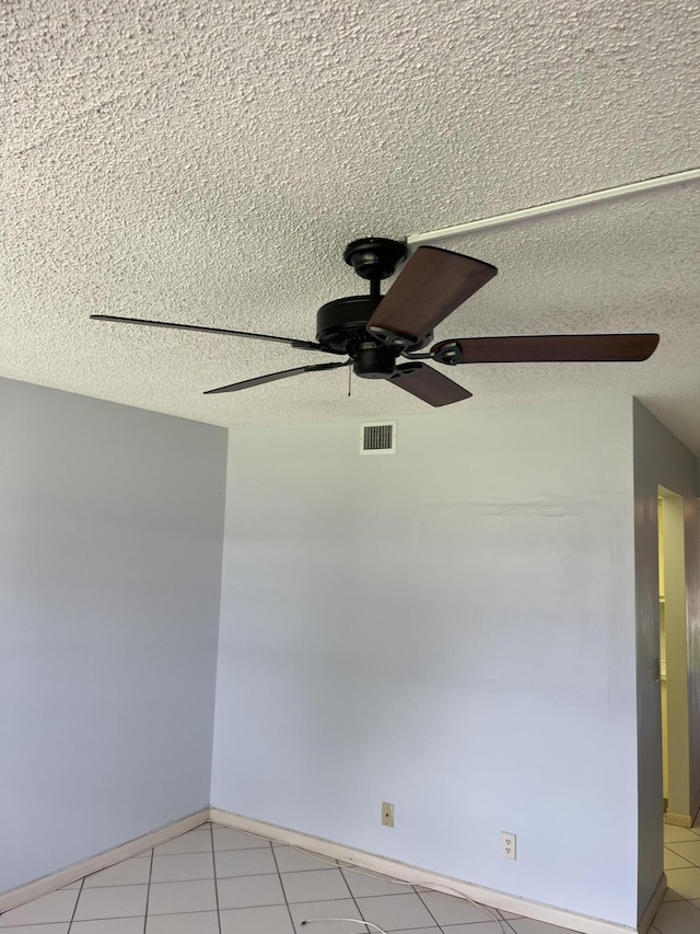 unfurnished room featuring a ceiling fan, light tile patterned floors, visible vents, and a textured ceiling